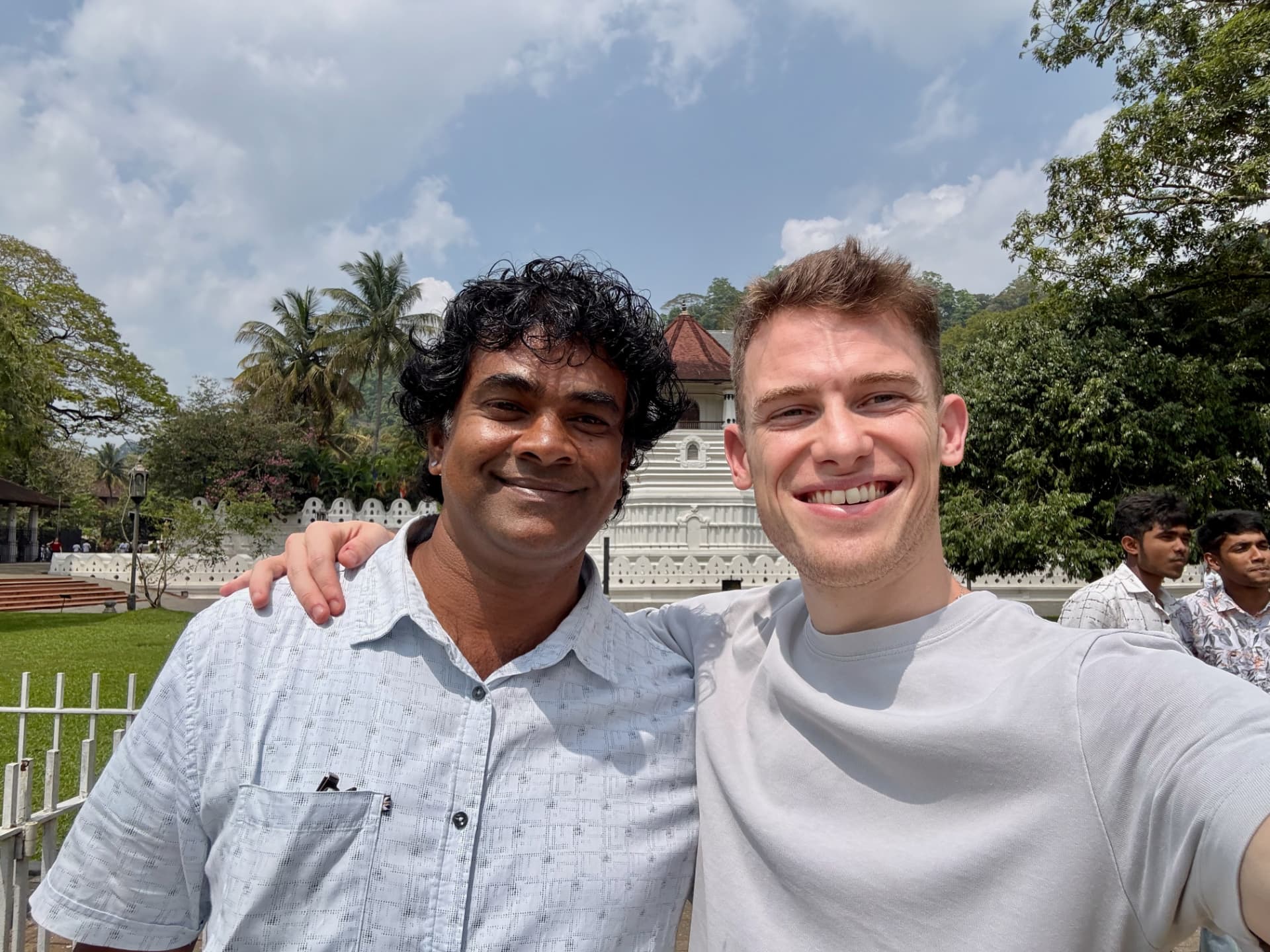 Selfie of Michael and Ram smiling outside a white temple in Kandy